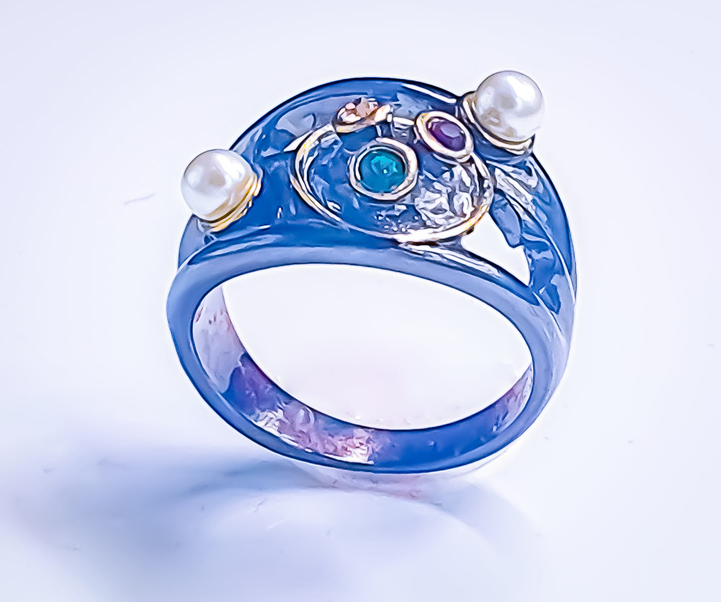 Raani's Sonata Ring - the black colour statement ring with faux pearls, whispers tales of romance and luxury. Captivating coloured glass stones rest within a halo of meticulously set glass pearls on a black-lacquered band. Skilled artisans crafted Raani's Sonata Ring with utmost care. Designed for elegance, the ring promises to catch every eye. The interplay of dark lacquer and sparkling gems creates a striking contrast.