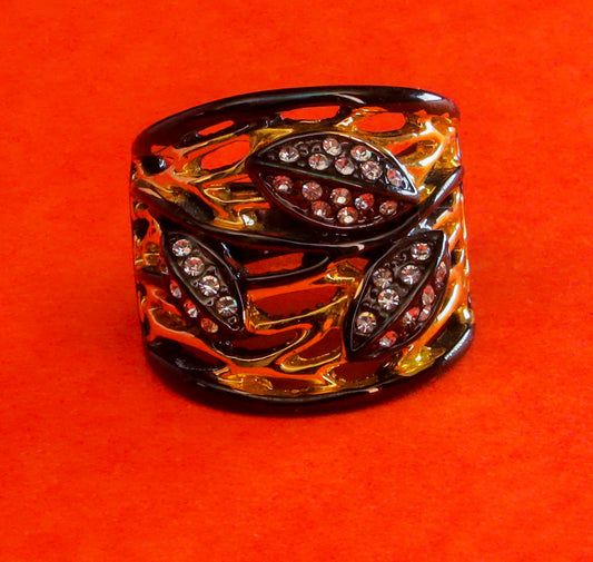 Introducing Raani's exquisite "Celestial Noir Brilliance Ring" – a stunning black and gold statement broad band ring that epitomizes elegance and allure. Crafted with unparalleled artistry, this masterpiece boasts a captivating fusion of celestial motifs and noir-inspired aesthetics, making it a true standout accessory.