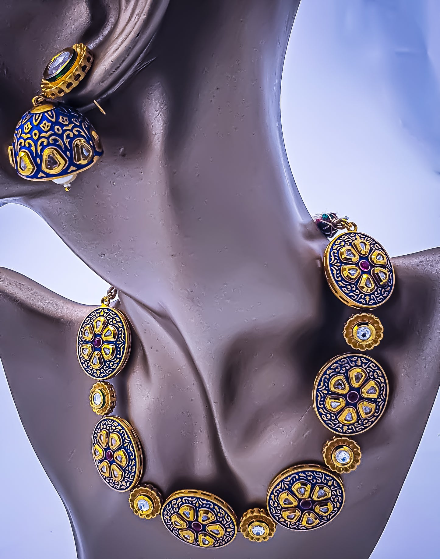 Introducing unique indigo blue choker set with kundan, a captivating symbol of regal elegance and timeless beauty. This exquisite ensemble features a magnificent necklace adorned with mesmerizing shades of indigo and delicate minakari, exuding opulence and sophistication. The regal charm extends to matching earrings, completing the set's enchanting allure.