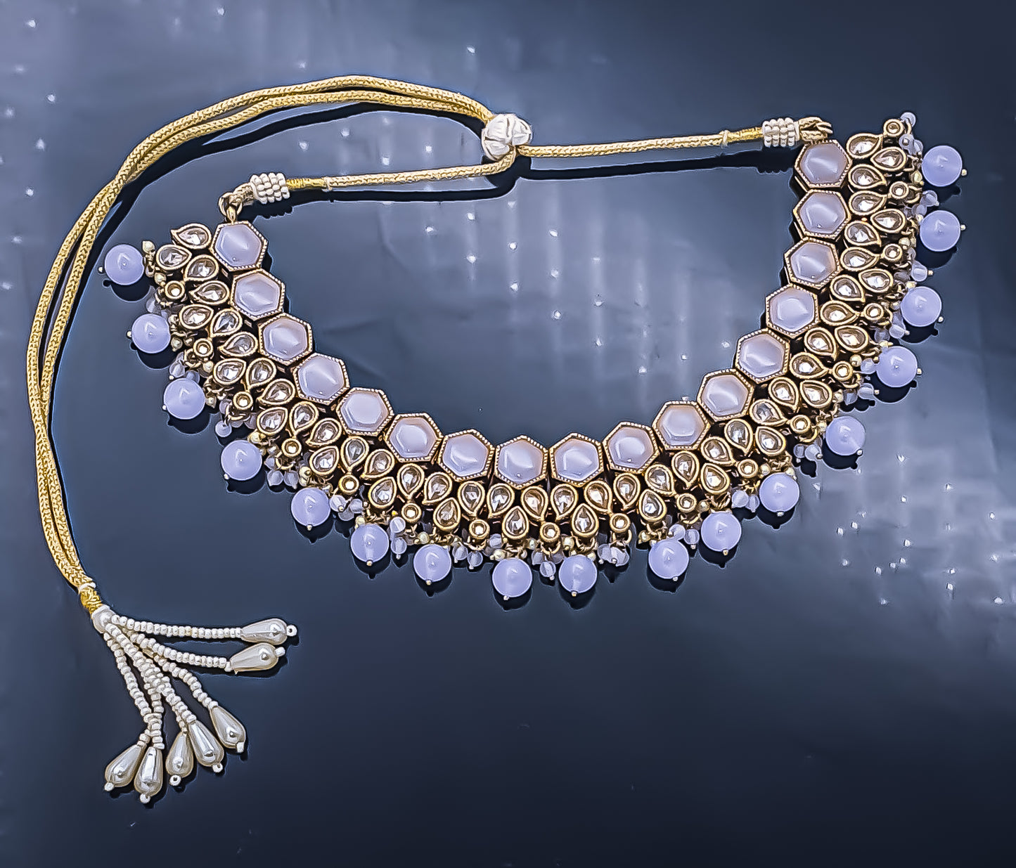 Step into a realm of unparalleled elegance with the mauve colour elegant choker necklace set with mang-tikka. This exquisite masterpiece exudes timeless allure, featuring a captivating blend of mauve-coloured stones and reverse American diamonds, meticulously crafted to perfection.