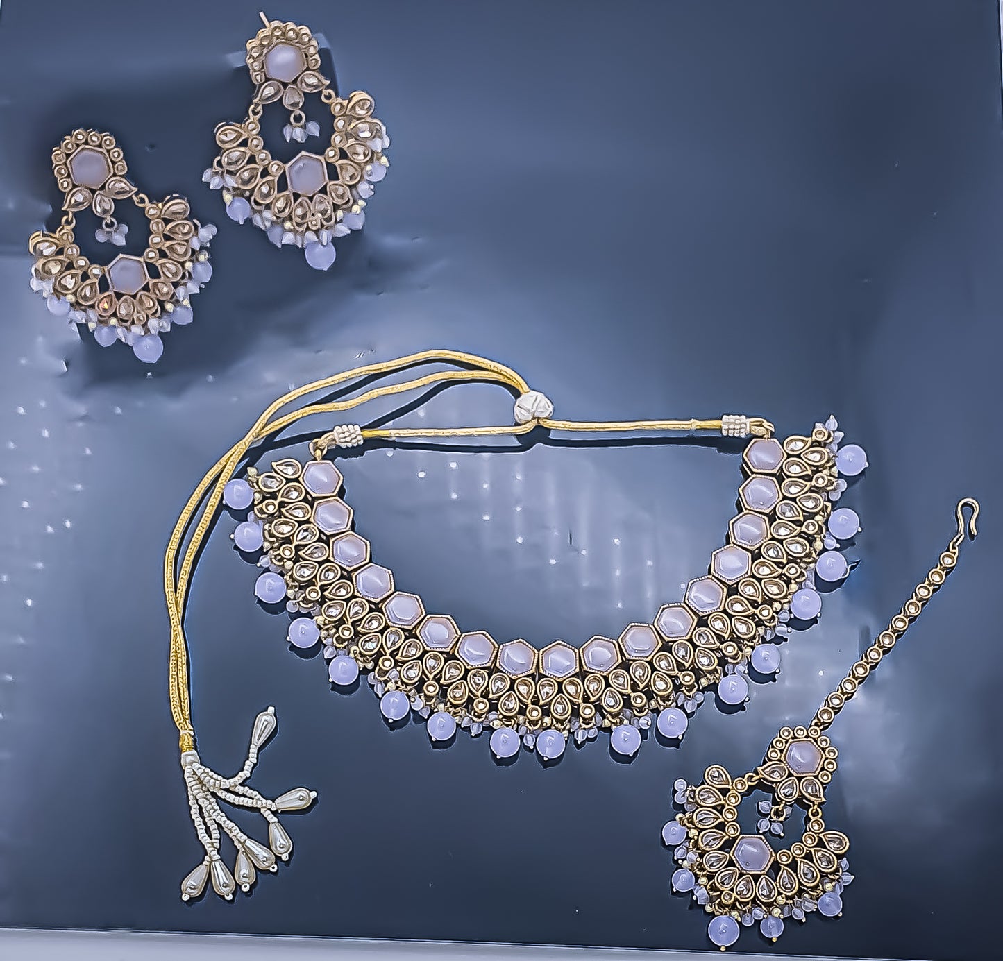 Step into a realm of unparalleled elegance with the mauve colour elegant choker necklace set with mang-tikka. This exquisite masterpiece exudes timeless allure, featuring a captivating blend of mauve-coloured stones and reverse American diamonds, meticulously crafted to perfection.