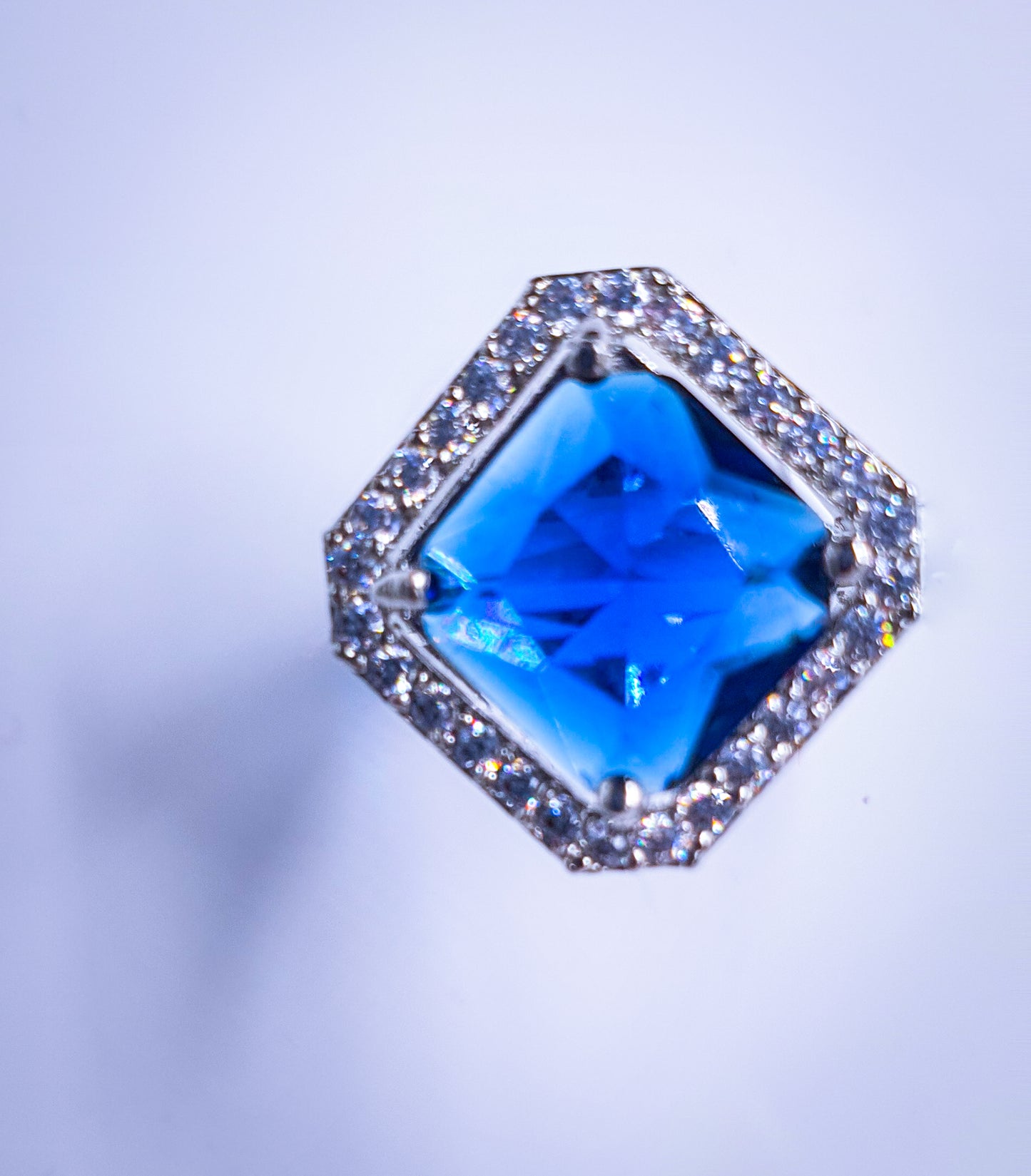 Introducing Raani's Radiant Blue Glass Stone Ring, a royal blue statement ring for women that embodies elegance and sophistication. This stunning piece features a captivating blue glass stone at its centre, surrounded by shimmering American diamonds. Crafted with meticulous attention to detail, it exudes timeless beauty.