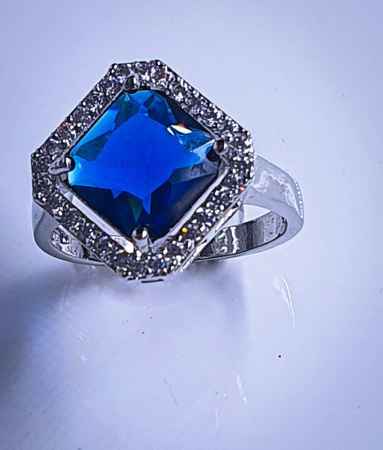 Introducing Raani's Radiant Blue Glass Stone Ring, a royal blue statement ring for women that embodies elegance and sophistication. This stunning piece features a captivating blue glass stone at its centre, surrounded by shimmering American diamonds. Crafted with meticulous attention to detail, it exudes timeless beauty.