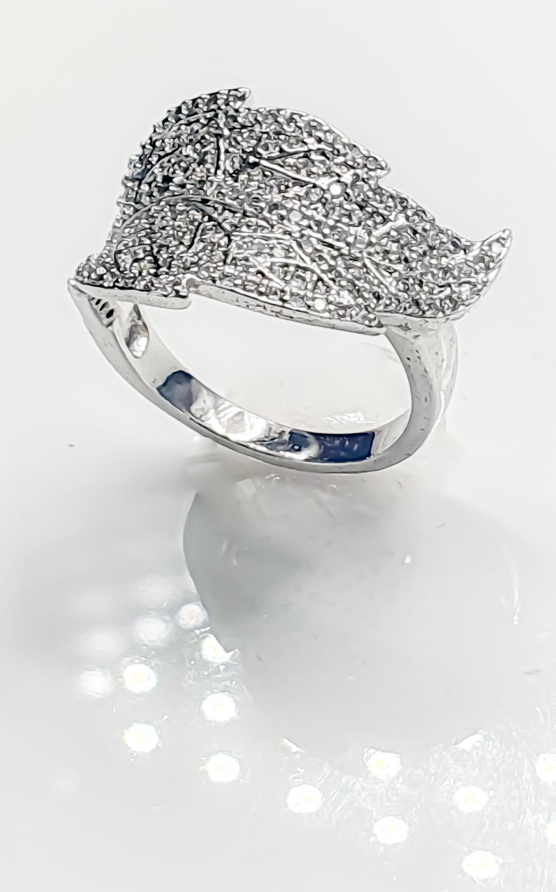 Introducing Raani's Soaring Feather Ring, a stunning silver colour statement ring with cubic zirconia that captures the essence of flight and boundless spirit. This exquisite piece features a delicate, sculpted feather design, symbolising dreams taking wing and limitless possibilities. The intricate feather detailing, adorned with sparkling cubic zirconia, adds a touch of brilliance and elegance to the ring.