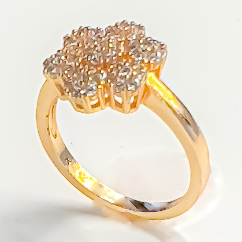 Dazzle with Raani's Golden Blossom Ring, a minimalist statement ring with cubic zirconia. This exquisite piece features a floral cluster of sparkling American Diamonds set against a gleaming gold-finish metal band, creating the luxurious look of fine jewellery.