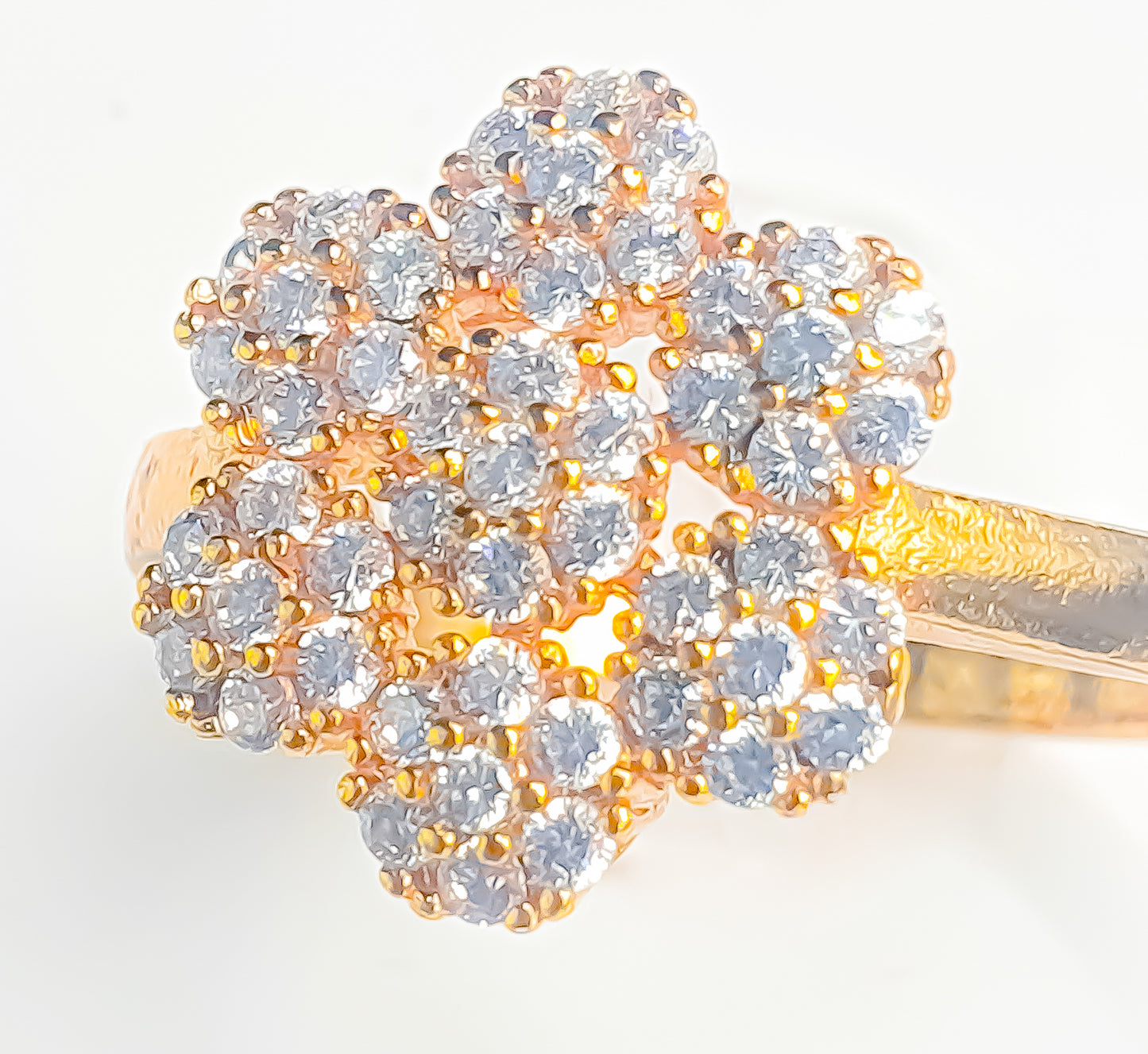 Dazzle with Raani's Golden Blossom Ring, a minimalist statement ring with cubic zirconia. This exquisite piece features a floral cluster of sparkling American Diamonds set against a gleaming gold-finish metal band, creating the luxurious look of fine jewellery.