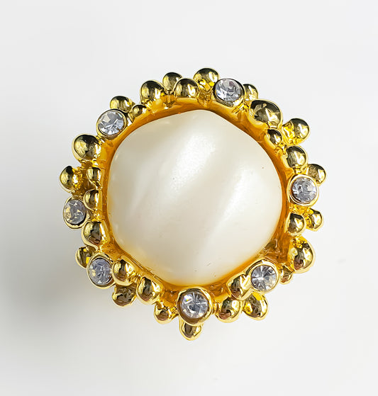 Presenting Raani's Luminous Pearl Ring, a rich gold plated faux baroque pearl statement ring that embodies classic elegance. This exquisite ring features a lustrous faux pearl in baroque style, accented by sparkling cubic zirconia on a gold-tone metal band. Its design offers a perfect blend of sophistication and glamour, suitable for both casual and dressier looks.