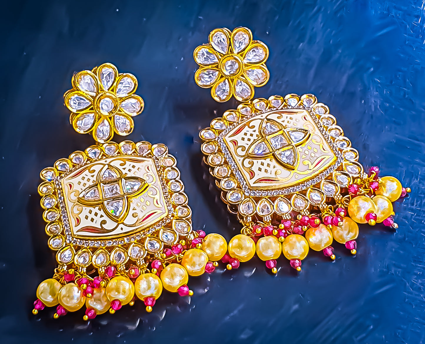 Introducing Raani's Ethnic Indian designer earrings with Kundan, pearls and cubic zirconia that are perfect for any special occasion. Aptly called Raani's Maya Earrings, these elegant earrings feature a gold-plated square design with intricate detailing, showcasing the beauty of traditional craftsmanship.