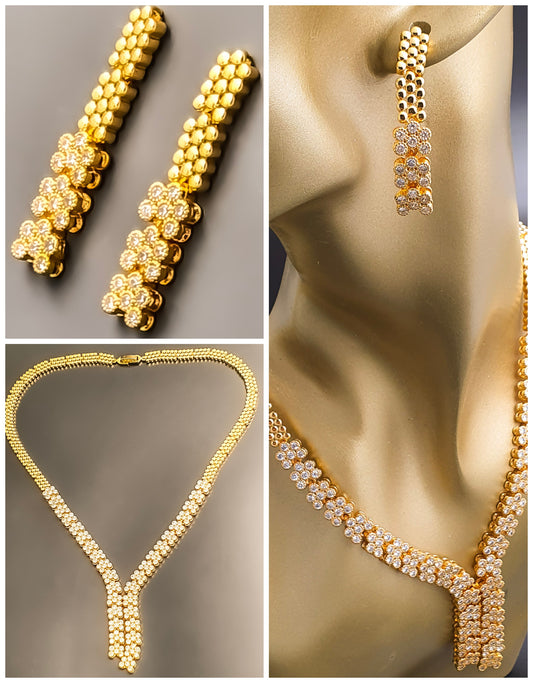 Introducing Raani's Golden Starlight Necklace Set, a rich gold plated designer necklace set that radiates enduring elegance. Crafted with high-quality gold plating and adorned with shimmering American Diamonds, this set dazzles with a celestial sparkle. Despite being artificial, the gold plating ensures lasting shine with proper care.