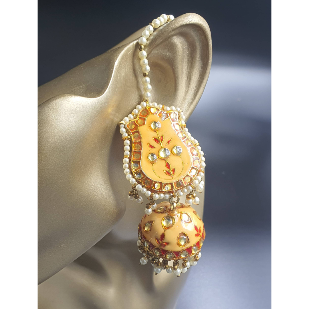 Introducing mustard yellow light-weight minakari jhumkas with little pearls !.&nbsp; Raani's Jhyank Jhumkas embody the timeless elegance of traditional Indian jewellery. Their intricate design and playful movement of glass pearls elevate any outfit, while their surprisingly lightweight construction ensures all-day comfort. Feel like royalty with these exquisite hand-crafted jhumkas.