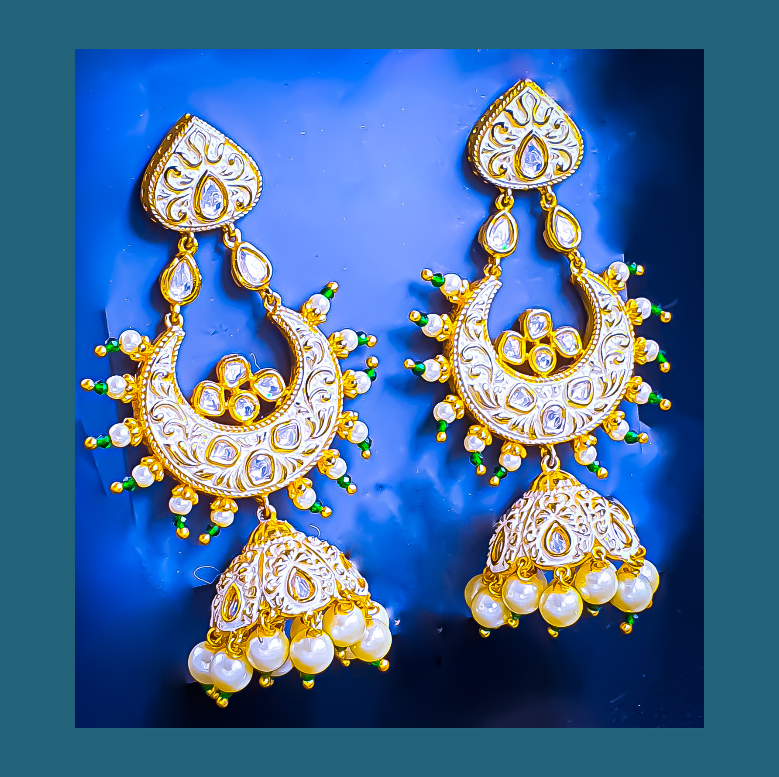 Raani's ivory colour Jodhpuri chandbali jhumkas with minakari and little pearls are a testament to exquisite Indian artistry. Gold-plated brass forms the intricate base, embellished with gleaming pearls and sparkling silver-foil kundan. The delicate golden minakari work on an ivory backdrop adds a touch of traditional colour, making these chandbali jhumka earrings a timeless treasure.