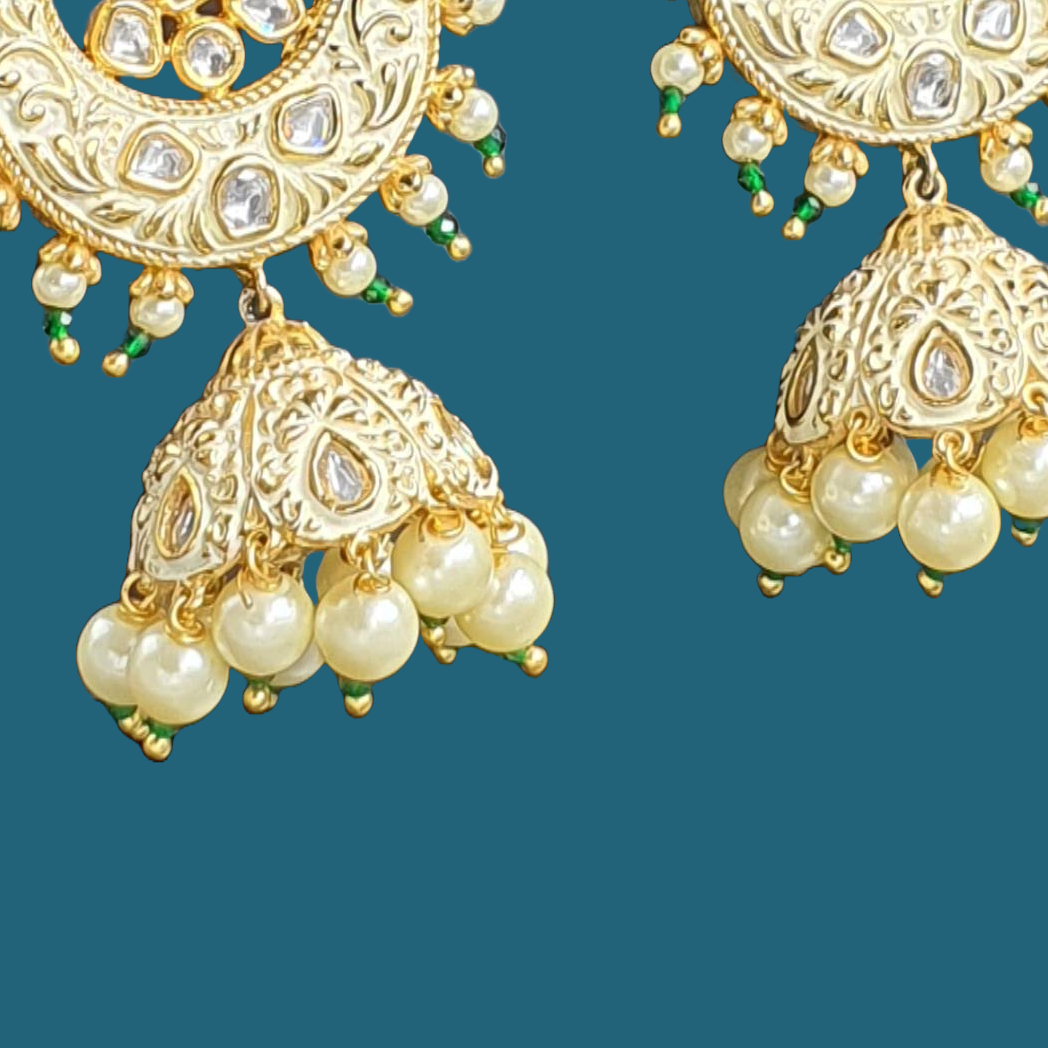 Raani's ivory colour Jodhpuri chandbali jhumkas with minakari and little pearls are a testament to exquisite Indian artistry. Gold-plated brass forms the intricate base, embellished with gleaming pearls and sparkling silver-foil kundan. The delicate golden minakari work on an ivory backdrop adds a touch of traditional colour, making these chandbali jhumka earrings a timeless treasure.